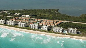 An aerial view of a coastal hotel with multiple buildings, a beach, and a large body of water. - ENJOY SUNRISES, SUNSETS FROM THIS BEAUTIFUL 7TH FLOOR HUTCHINSON ISLAND CONDO!! (Jensen Beach)