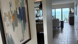 A spacious living area with a large abstract painting, a ceiling fan, and a view of the ocean. - ENJOY SUNRISES, SUNSETS FROM THIS BEAUTIFUL 7TH FLOOR HUTCHINSON ISLAND CONDO!! (Jensen Beach)