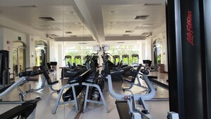 Una palestra con diverse attrezzature per esercizi, ampi specchi e un design moderno e pulito.