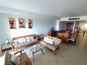 Un salon spacieux comprenant un ensemble de canapés, une table basse et un coin repas.