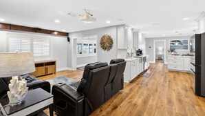 A spacious living area with a dining table, black leather chairs, a coffee table, and a decorative wall piece. - Canalfront 3BR Heated Pool With Boat Lift (Punta Gorda)