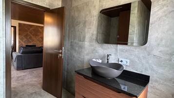Une salle de bain moderne avec un meuble-lavabo en bois, un vasque et un grand miroir.