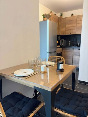 A modern kitchen with wooden cabinets, a built-in oven, and a microwave. - L'Onda Serena - sleeps 4, 5 min from the beach (Ajaccio)