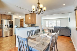 A modern kitchen with wooden cabinets, a stainless steel refrigerator, and a dining area with a wooden table and chairs. - 26 Mi to MetLife & NYC: 1 mi to Train (Scotch Plains)