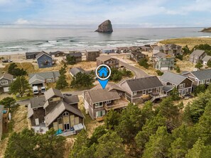 A coastal residential area with houses, a beach, and a rocky outcrop in the distance. - Pelican Watch - - Block from Beach w/Hot Tub Dog Friendly (Cloverdale)