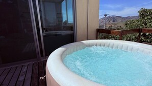 A hot tub on a wooden deck with a clear view of the surrounding landscape. - Beautiful apartment with a private Jacuzzi (Jal.)