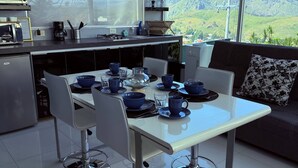 A modern kitchen with a dining area, large windows, and a view of the countryside. - Beautiful apartment with a private Jacuzzi (Jal.)