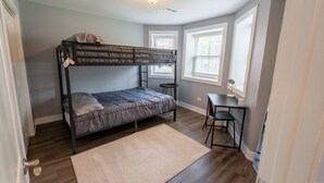 A bunk bed room with a desk and chair, a window, and a door. - 2 Bedroom apartment free parking near transit (Chicago)