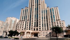 A high-rise residential building with multiple balconies, a central entrance, and a clear sky. - Vibrant 2 Bed l The Greens l Family Retreat (The Greens)