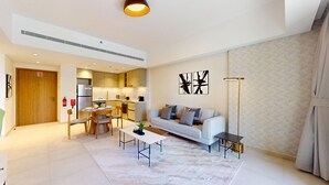 A modern living room with a sofa, coffee table, and dining area. - Luxury Living 1 Bed l Pool View l Burj Al Arab (Madinat Jumeirah Living)