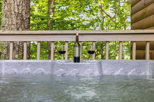 A hot tub with two glasses of red wine, surrounded by a wooden deck and trees. - Unobstructed Smoky Mountain Views, Hot Tub, Pigeon Forge (Pigeon Forge)