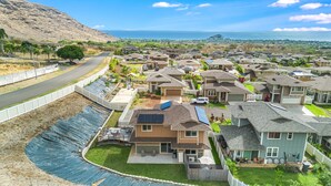 A residential area with houses, a road, and a view of the ocean.