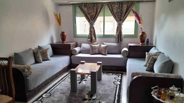 A living room with a sofa set, a coffee table, and a rug. - Apartment Gueliz - Near ONCF station - Marrakech (Marrakech)