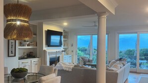 Ein großzügiger Wohnbereich mit modernem Design, der ein großes Sofa, einen Glastisch und einen Fernseher umfasst.