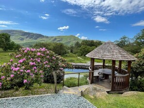A gazebo with a wooden roof and a stone pathway leading to it. - Mary Mount Hotel (Keswick)