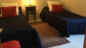 A hotel room with two beds, a nightstand with a lamp, and a patterned rug. - Delightful 2-bedroom cottage perfect for a revitalizing retreat in Brittany (Ruffiac)