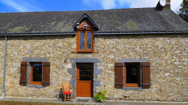 A stone building with a central wooden door, two windows with shutters, and a satellite dish on the roof. - Delightful 2-bedroom cottage perfect for a revitalizing retreat in Brittany (Ruffiac)