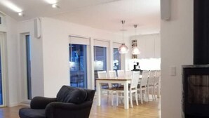 Una sala de estar moderna con un sofá oscuro, piso de madera y una chimenea.