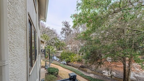 A balcony with a view of a water feature and surrounding greenery. - 2BR Lagoon View Villa - Walk to Coligny (Hilton Head Island)