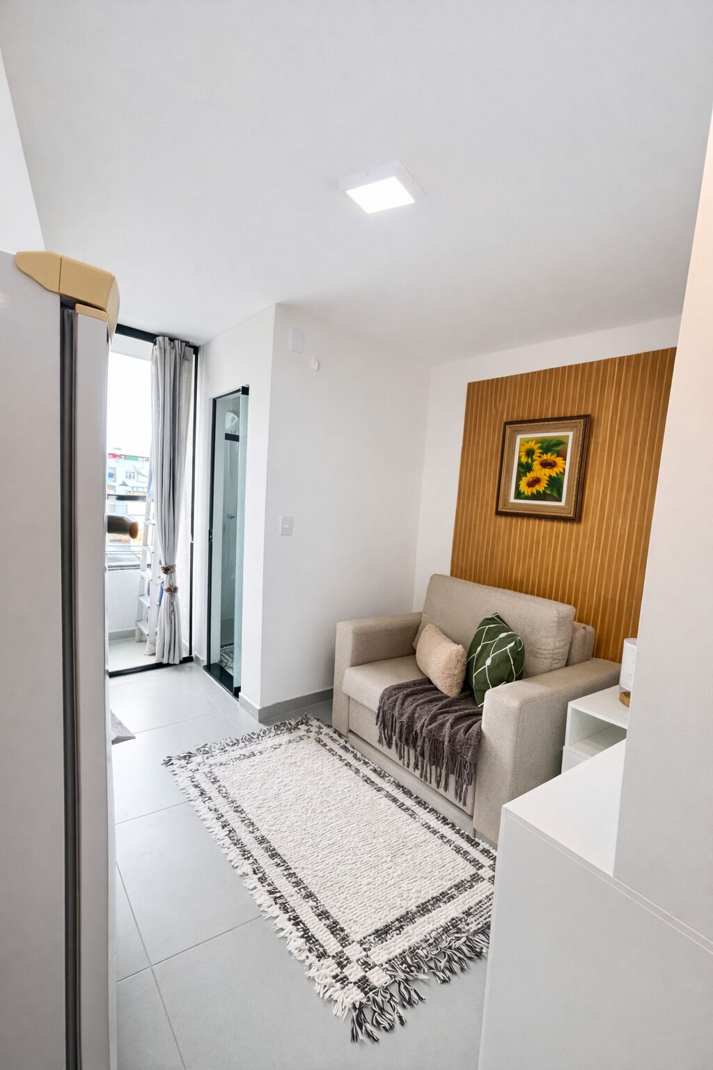 Un salon moderne avec un canapé, un tapis à motifs et un tableau encadré accroché au mur.