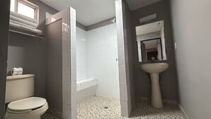 Un baño con inodoro, ducha y lavamanos.