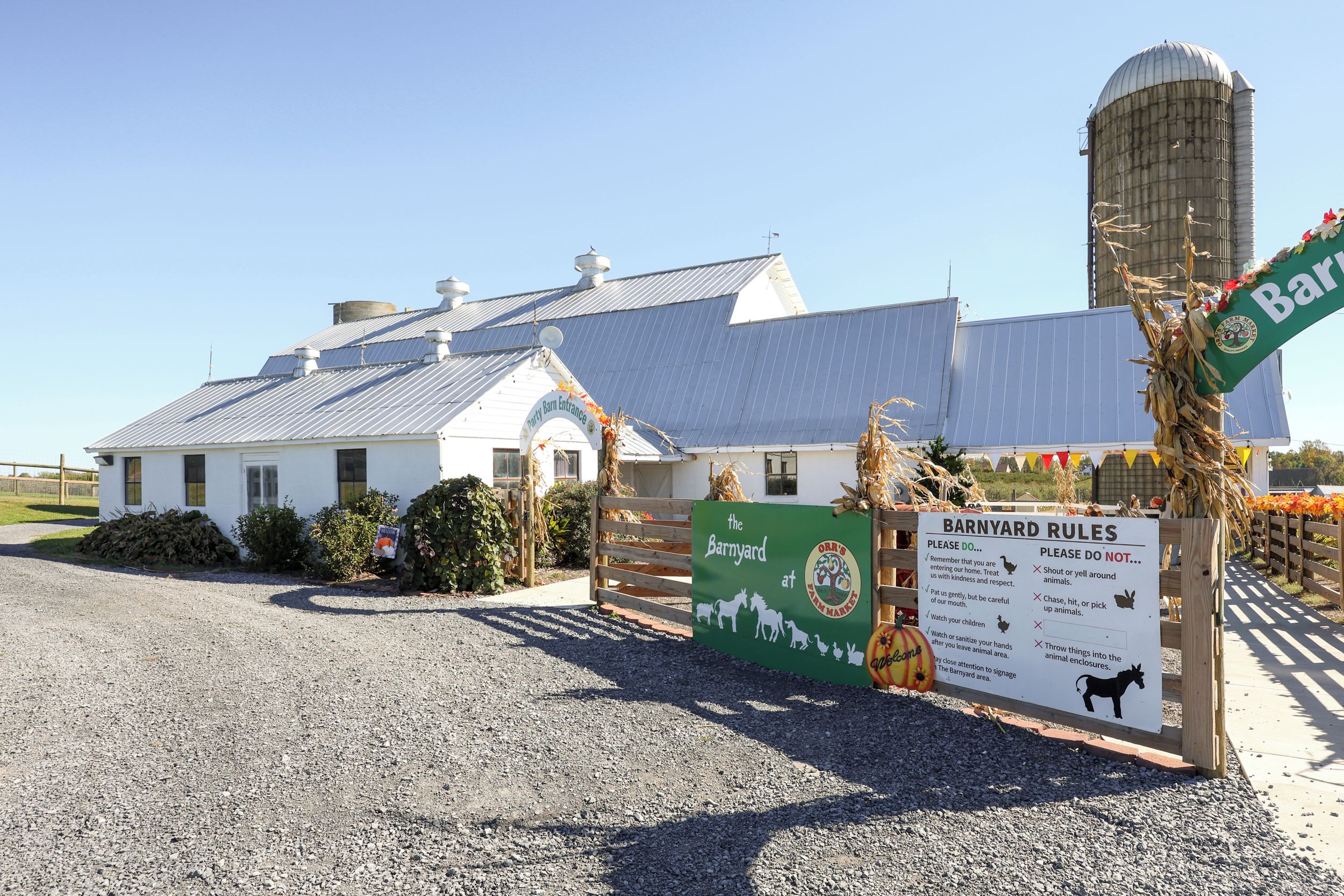 A barn with a sign indicating 'Barnyard Rules' and a 'Party Barn Entrance' sign.