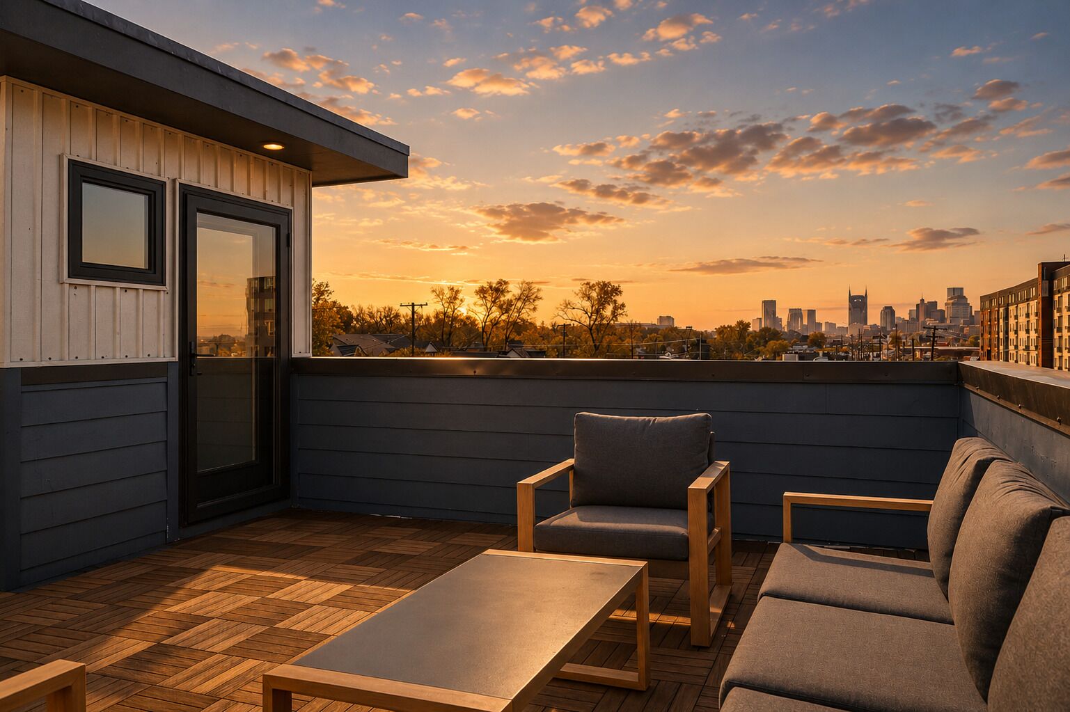 Terraza en la azotea con vistas al horizonte urbano, suelo de madera y mobiliario exterior.