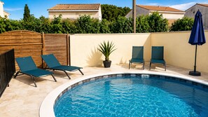 Una piscina amb gandules i una planta en test.