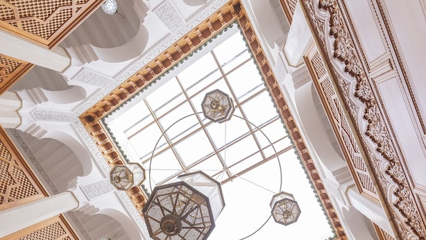 An ornate interior with intricate carvings, a large skylight, and a central chandelier. - Riad Jnane Zephyr (Marrakech)