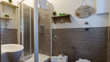 Baño con ducha, bidé, inodoro y lavamanos.