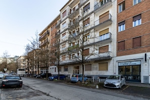 A multi-story residential building with balconies, parked cars, and a storefront. - Feel Good - Downtown Varese - Apartment for 2 people - Free Wi-Fi - By Guestaly (Varese)
