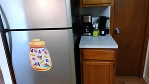 Eine Küche mit Holzausstattung, einem Edelstahlkühlschrank und einer Kaffeemaschine auf der Arbeitsfläche.