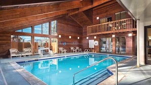 An indoor swimming pool with a wooden deck, lounge chairs, and a balcony overlooking the pool. - 1BR, Sleep 4, Club Wyndham Steamboat Springs, Ski Shuttle, Pool/Spa (Steamboat Springs)