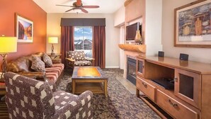 A hotel room with a sofa, armchairs, a coffee table, a TV, and a fireplace. - 1BR, Sleep 4, Club Wyndham Steamboat Springs, Ski Shuttle, Pool/Spa (Steamboat Springs)