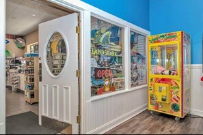Een winkelinterieur met een rond raam, een automaat en diverse producten op planken.