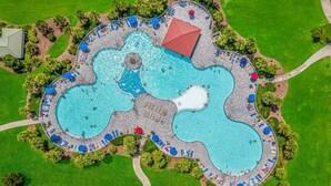 Vista aerea di un resort con diverse piscine collegate, aree relax e palme.