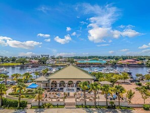 A marina with boats, a building with a green roof, and palm trees. - Tee Off by the Sea – Barefoot Golf Escape (North Myrtle Beach)