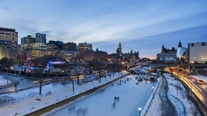 Une vue urbaine avec une rivière gelée, des bâtiments et un pont.