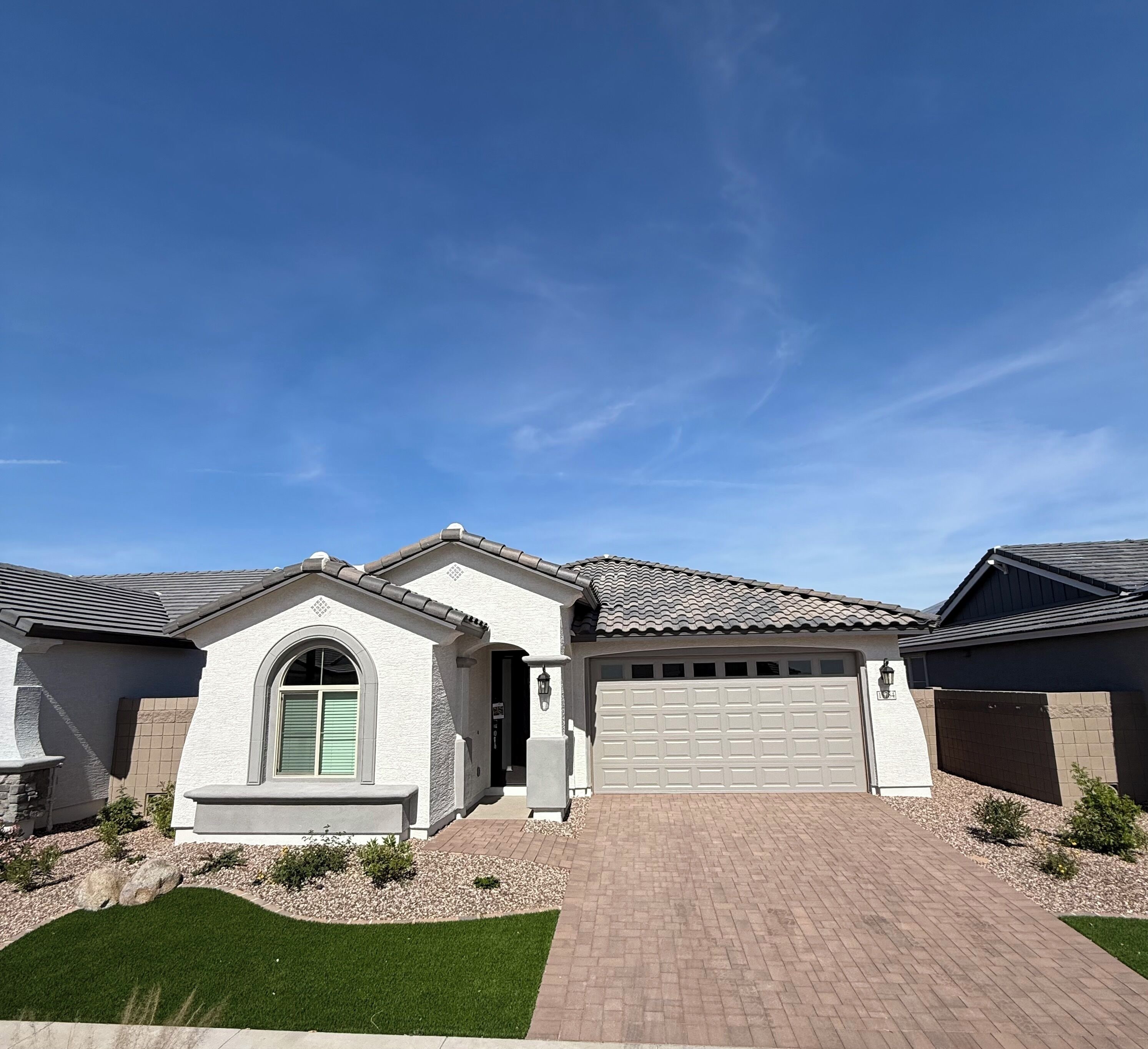 A two-story house with a garage, a driveway, and a well-maintained lawn.