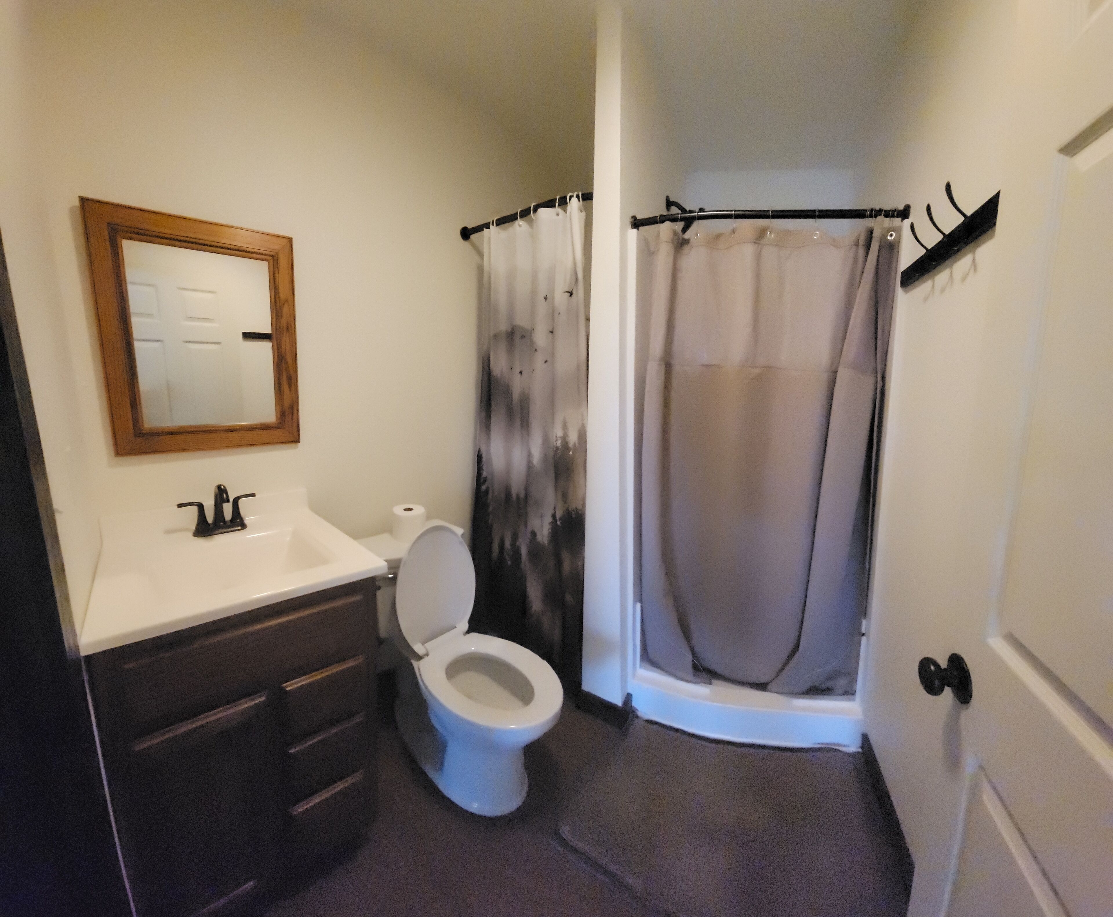 Un bagno con il water, lavandino e tenda da doccia.