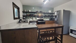 Een kleine keuken met een houten bar, roestvrijstalen apparatuur en een inbouwoven.