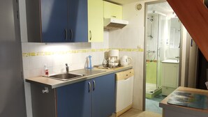 A compact kitchen with blue cabinets, a white dishwasher, and a coffee maker on the counter. - Practical house, pets welcome - 6 guests (La Tranche-sur-Mer)