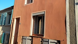 Um edifício com três janelas e uma varanda.