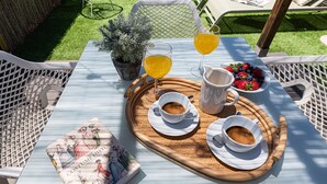 A table set with two cups of coffee, a tray with a book, a pitcher, and a bowl of fruit. - Apartment with private terrace - 4 guests (Málaga)