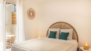 A bedroom with a bed, a bedside lamp, and a view of an outdoor area.