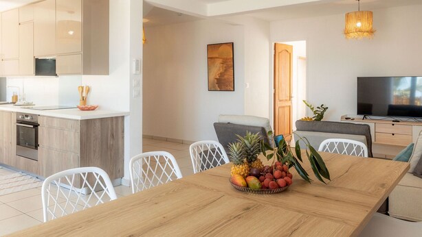 A modern kitchen with white cabinets and a built-in oven.