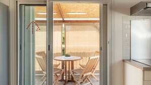 A modern kitchen with a built-in oven and a dining area with a round table and four wooden chairs.