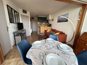 Een functionele ruimte met eethoek, kitchenette en een zithoek.