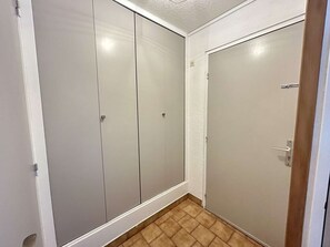 A room with a sliding door closet, a door with a handle, and a tiled floor. - Bright apartment with private parking - 5 guests (Cap d'Agde)