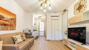 Una sala de estar moderna con un sofá, un televisor y un cuadro en la pared.